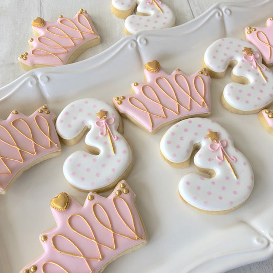 pink and white iced biscuits with crown and age shape