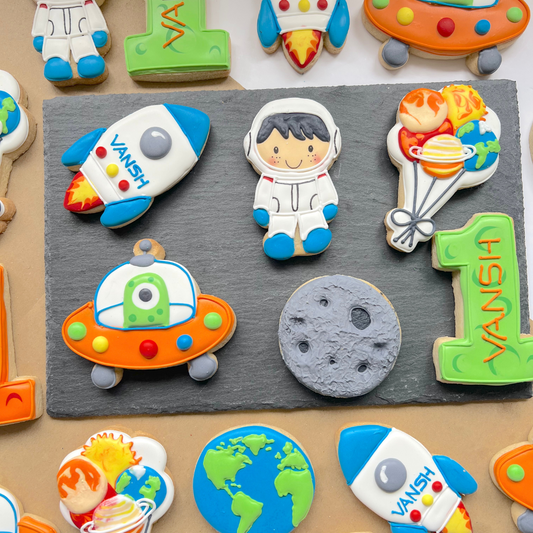 iced biscuits including astronaut rocket and alien shapes for space birthday party favours